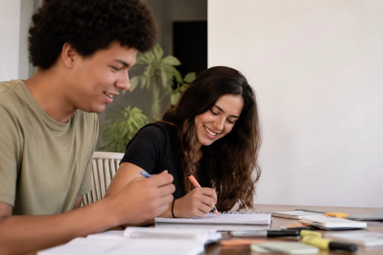 Dois estudantes preparando um debate com cadernos e marcadores